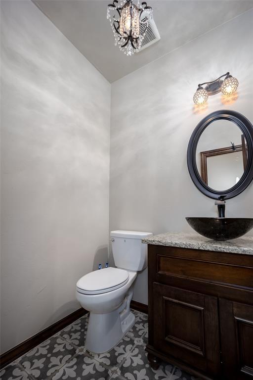 bathroom featuring vanity, a notable chandelier, and toilet