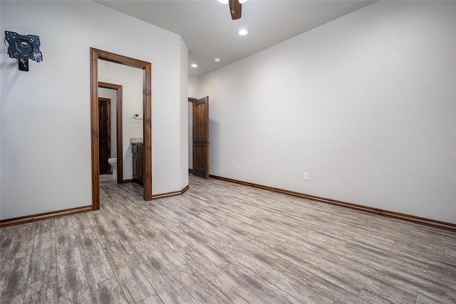 spare room with ceiling fan and light wood-type flooring