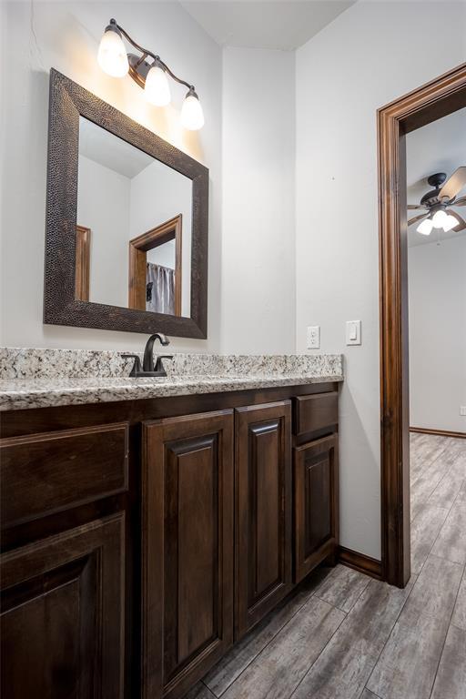 bathroom with ceiling fan, vanity, and hardwood / wood-style floors