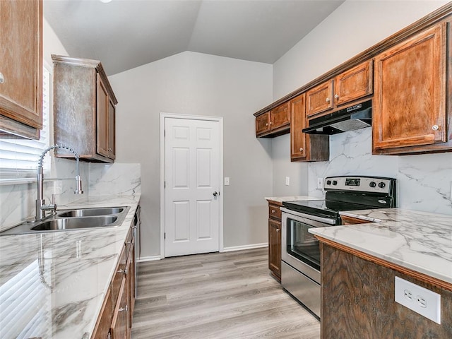 kitchen with sink, stainless steel range with electric stovetop, light stone counters, vaulted ceiling, and light wood-type flooring