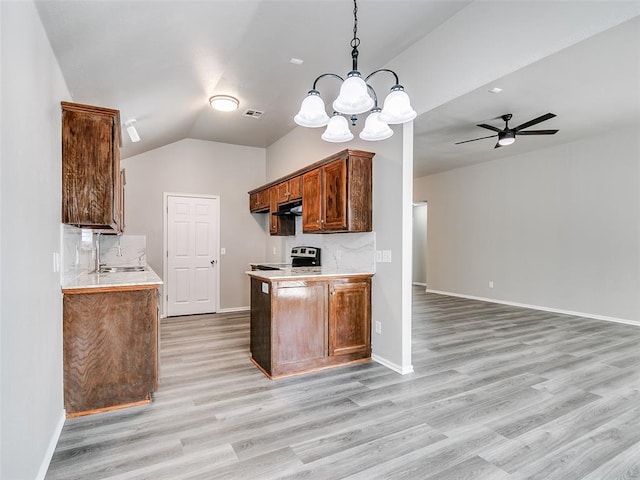 kitchen with hanging light fixtures, backsplash, light hardwood / wood-style floors, stainless steel electric range oven, and vaulted ceiling