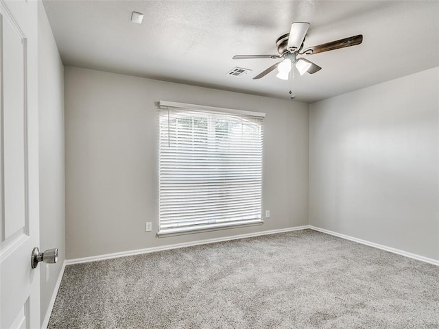 carpeted spare room featuring ceiling fan