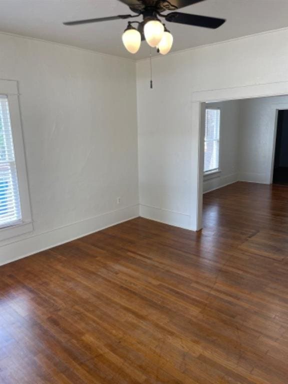 empty room with dark hardwood / wood-style flooring and ceiling fan