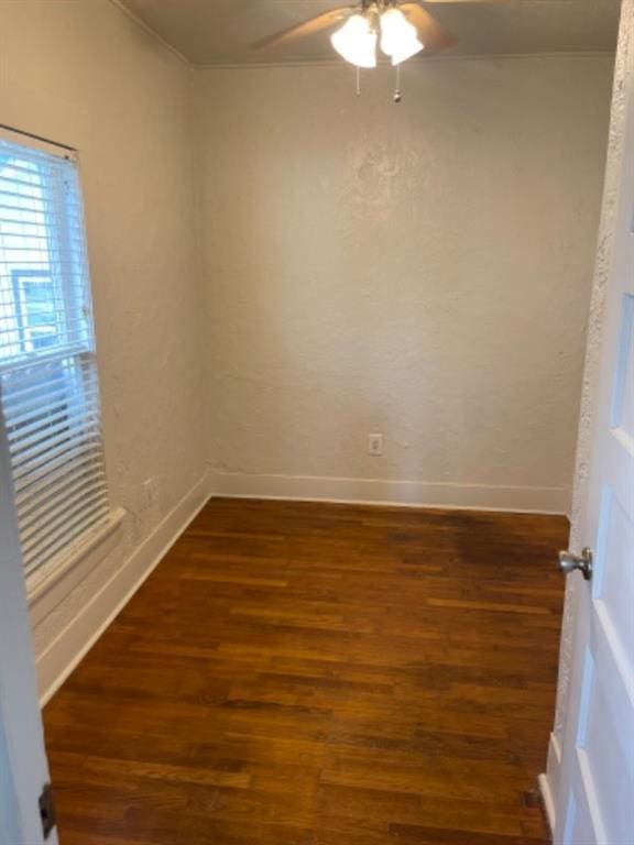 unfurnished room featuring dark hardwood / wood-style flooring, ornamental molding, and ceiling fan