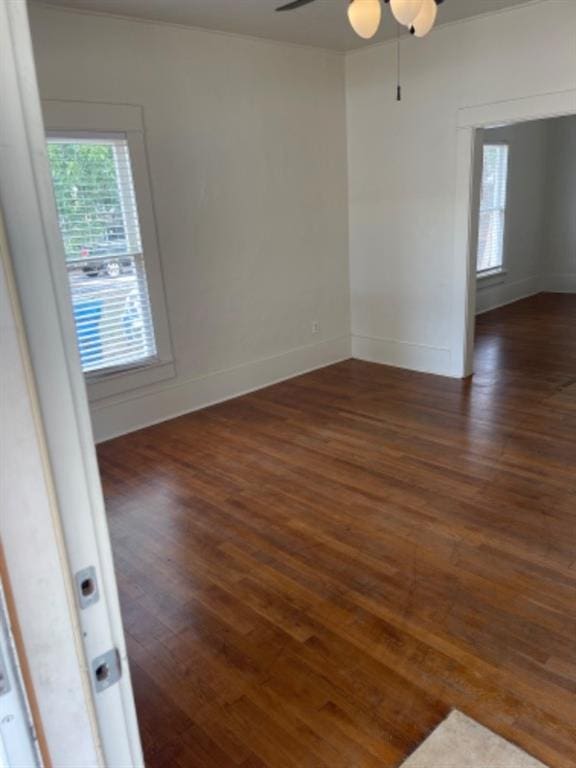 spare room with dark hardwood / wood-style flooring and ceiling fan