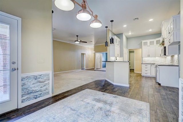 kitchen featuring white cabinetry, hanging light fixtures, dark hardwood / wood-style flooring, ceiling fan, and decorative backsplash