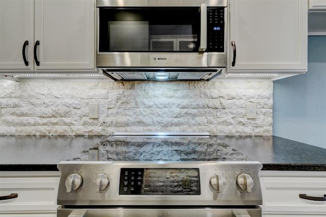 kitchen with backsplash, white cabinets, and appliances with stainless steel finishes