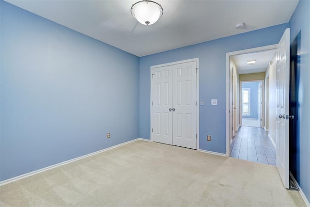 unfurnished bedroom featuring a closet and light carpet