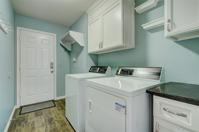 clothes washing area featuring cabinets, dark hardwood / wood-style floors, and independent washer and dryer