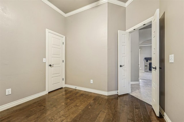 unfurnished bedroom with crown molding and dark wood-type flooring