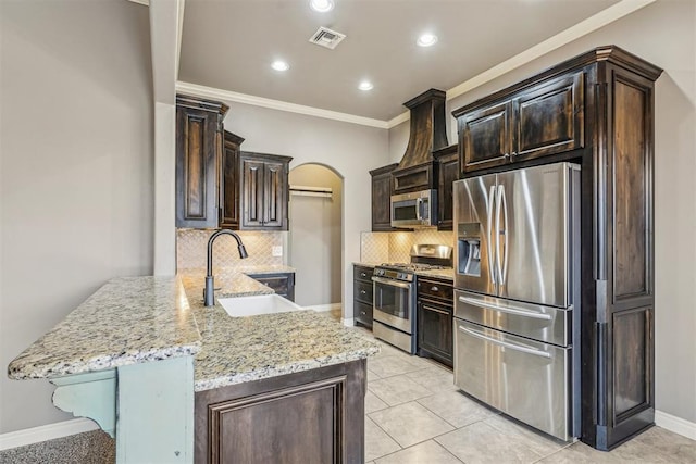 kitchen featuring appliances with stainless steel finishes, sink, backsplash, kitchen peninsula, and light stone countertops