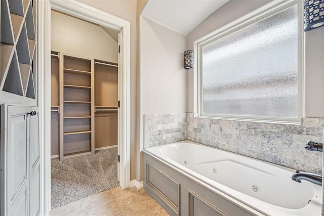 bathroom featuring a bath, vaulted ceiling, and tile patterned floors