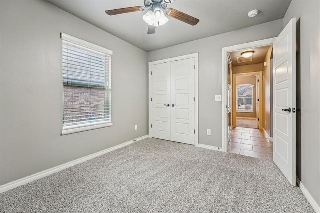 unfurnished bedroom featuring ceiling fan, carpet flooring, and a closet