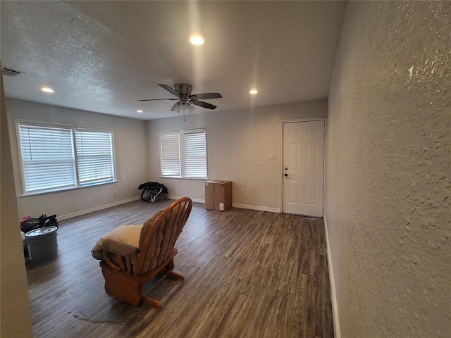 sitting room featuring dark hardwood / wood-style flooring, a textured ceiling, and ceiling fan