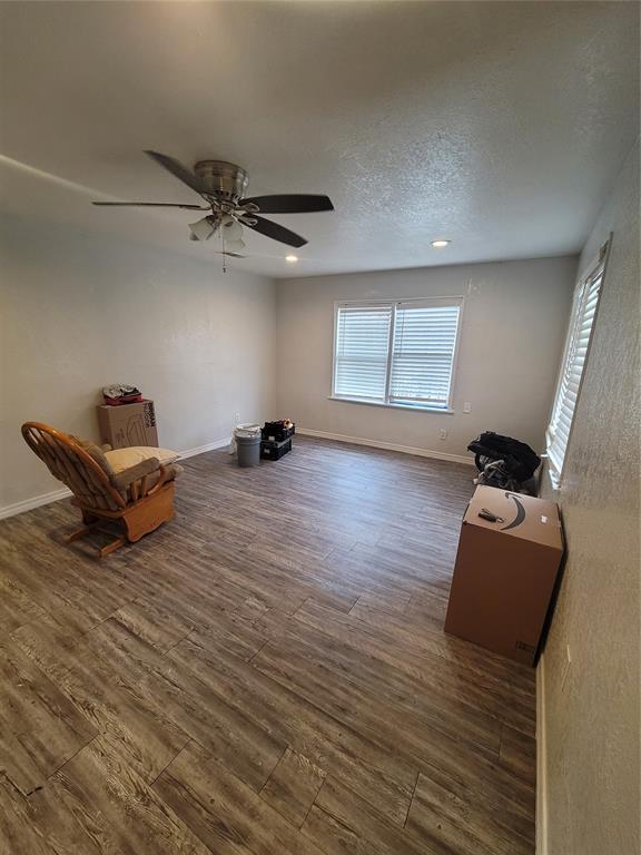 unfurnished room with ceiling fan, a textured ceiling, and dark hardwood / wood-style flooring