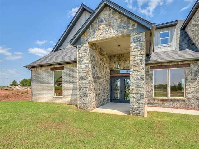 back of property featuring french doors and a lawn