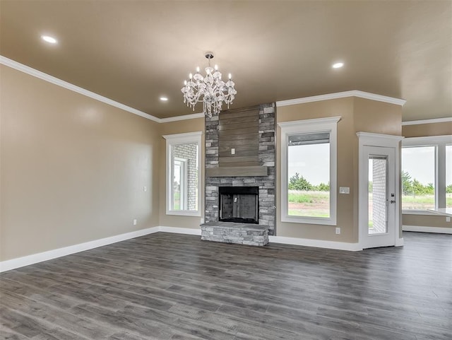 unfurnished living room featuring ornamental molding, dark wood-type flooring, an inviting chandelier, and a fireplace