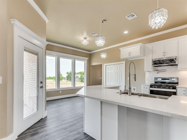 kitchen featuring white cabinetry, hanging light fixtures, gas range, and light stone countertops