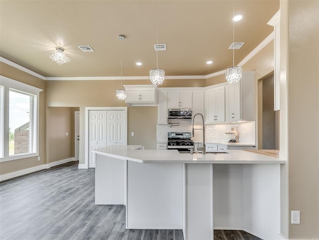 kitchen featuring white cabinetry, pendant lighting, stainless steel appliances, and crown molding