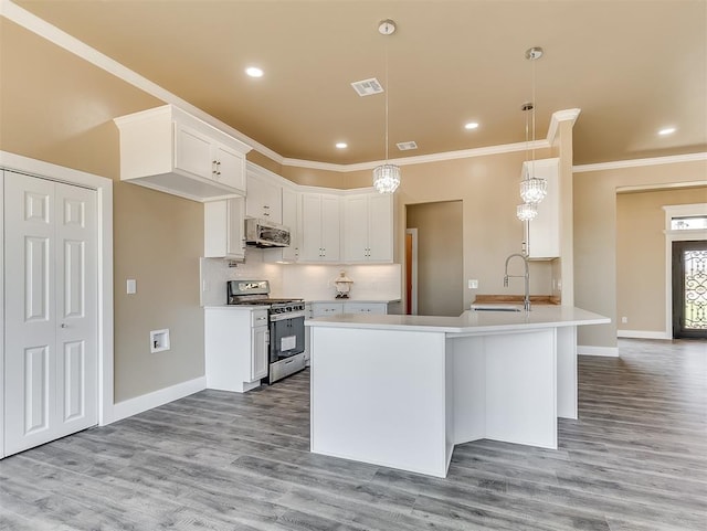 kitchen with appliances with stainless steel finishes, sink, hanging light fixtures, and white cabinets