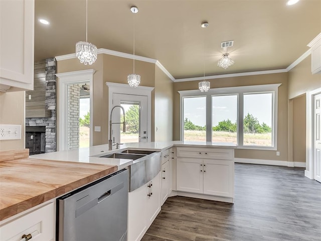 kitchen with dishwasher, sink, white cabinets, and decorative light fixtures