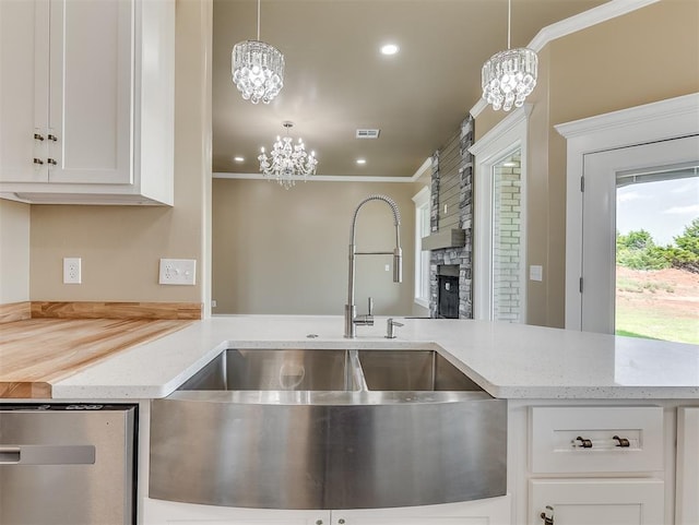 kitchen featuring white cabinetry, sink, pendant lighting, and a chandelier