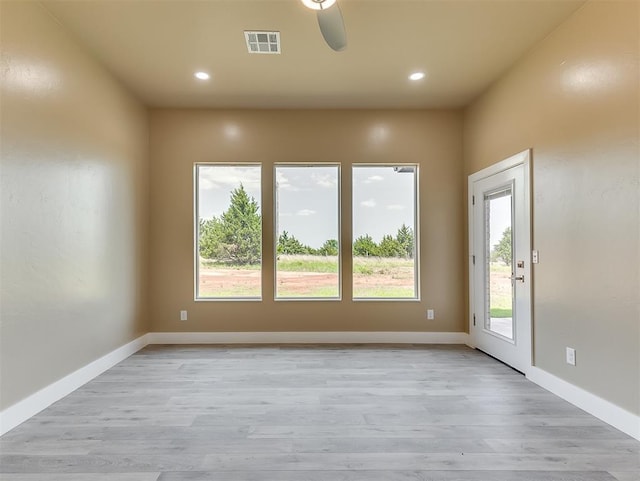 empty room with ceiling fan and light hardwood / wood-style floors