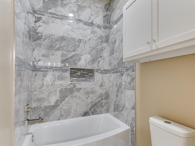 bathroom featuring toilet and tiled shower / bath combo