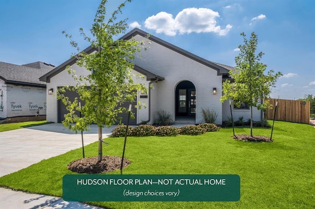 view of front of home with a garage and a front lawn