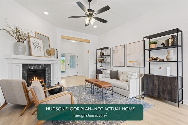 living room featuring ceiling fan, a high end fireplace, and light hardwood / wood-style floors