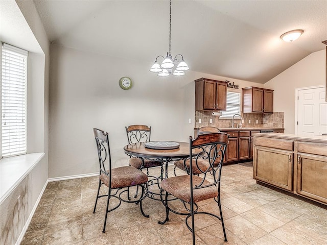 dining space with lofted ceiling, sink, and a chandelier