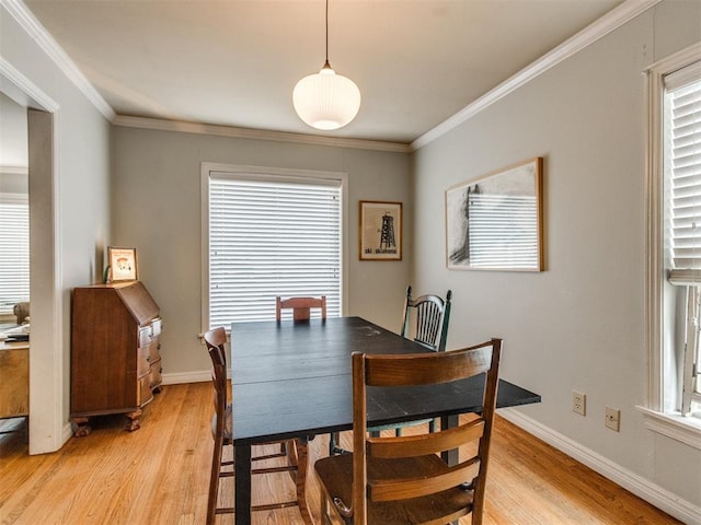 dining room featuring crown molding and light hardwood / wood-style flooring