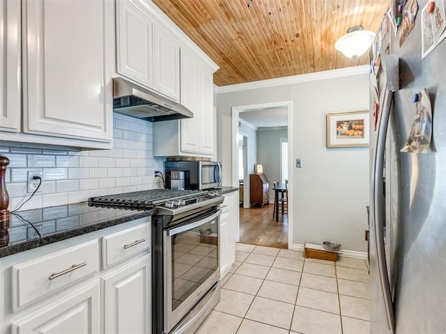 kitchen with light tile patterned flooring, ornamental molding, stainless steel appliances, and white cabinets