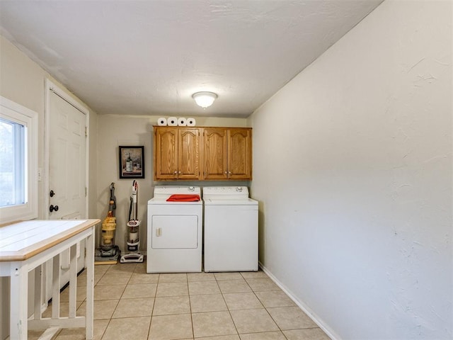 laundry room featuring cabinets, washer and clothes dryer, and light tile patterned floors