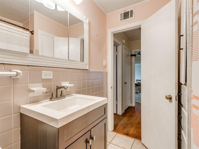 bathroom with vanity, tile patterned flooring, and tile walls