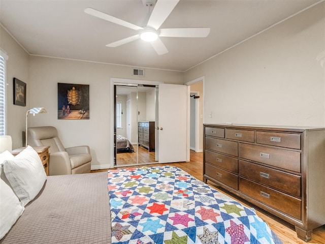 bedroom with ceiling fan, light hardwood / wood-style floors, and a closet