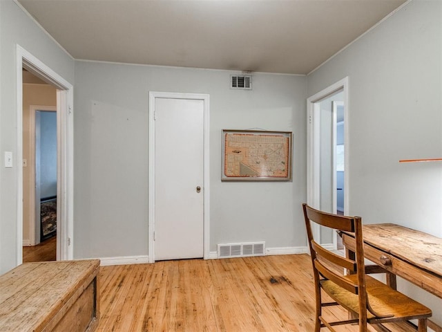 dining room featuring crown molding and light hardwood / wood-style flooring