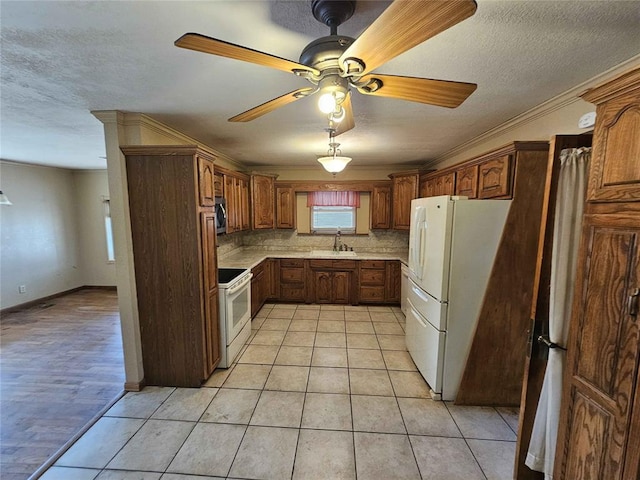 kitchen featuring light tile patterned flooring, white appliances, sink, and a textured ceiling