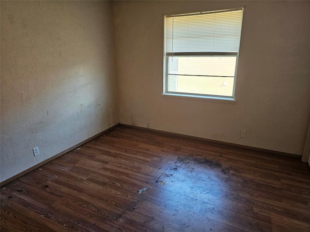 empty room with dark hardwood / wood-style flooring