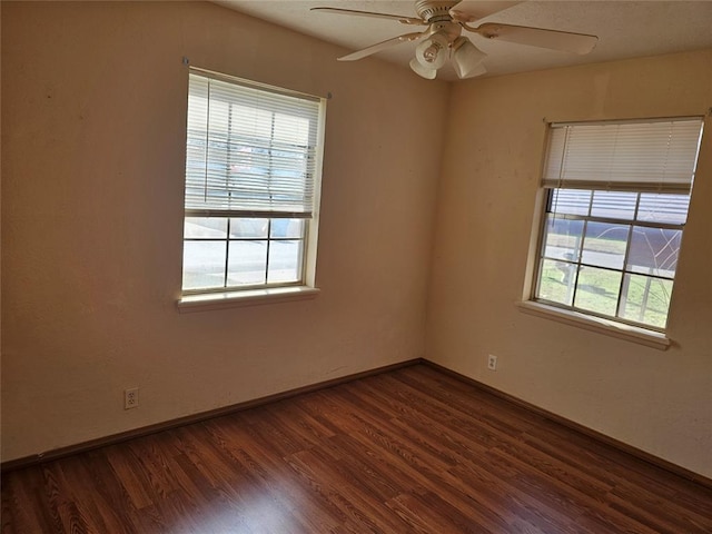 empty room with dark hardwood / wood-style floors and ceiling fan