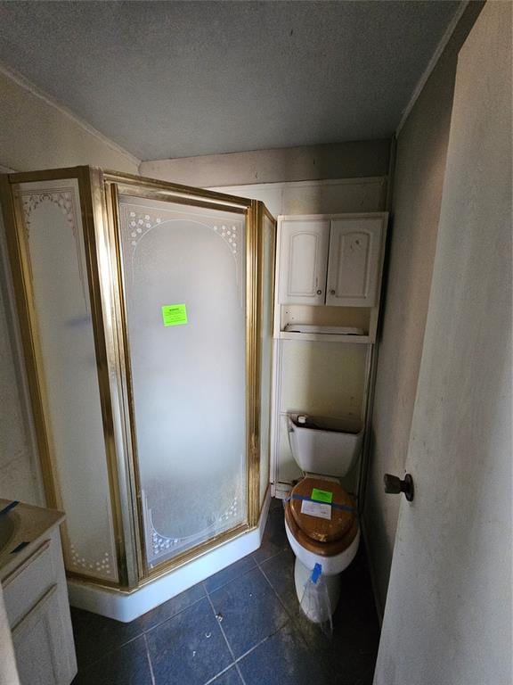 bathroom with tile patterned flooring, vanity, toilet, a shower with door, and a textured ceiling