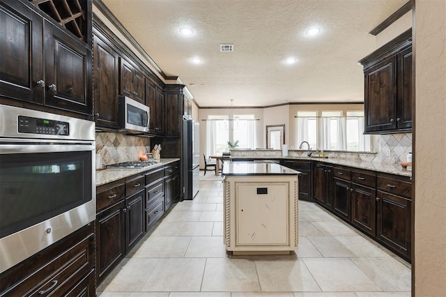 kitchen with tasteful backsplash, light tile patterned floors, ornamental molding, and appliances with stainless steel finishes