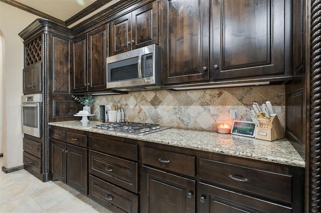 kitchen with appliances with stainless steel finishes, dark brown cabinets, and decorative backsplash