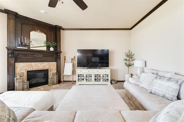 carpeted living room featuring crown molding, ceiling fan, and a fireplace