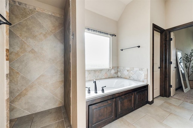 bathroom featuring a bath and vaulted ceiling