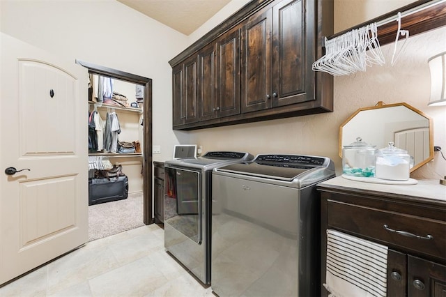 laundry area featuring independent washer and dryer, cabinets, and light colored carpet