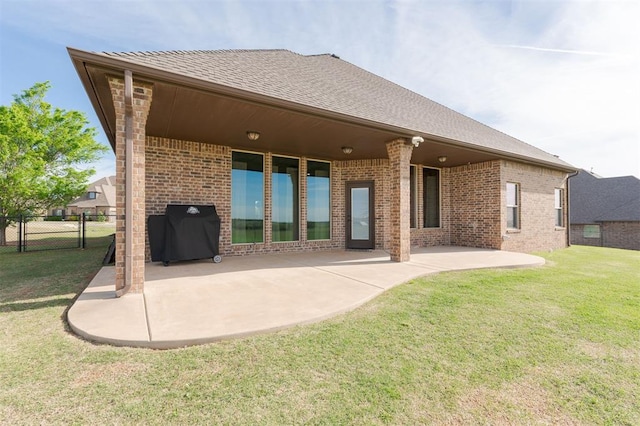 rear view of house featuring a yard and a patio