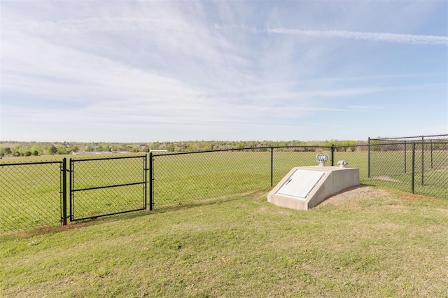 entry to storm shelter with a rural view and a lawn