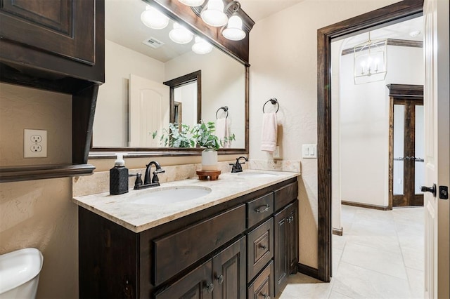 bathroom with vanity, tile patterned flooring, a chandelier, and toilet