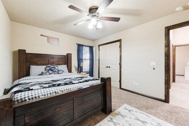 bedroom featuring light carpet, a textured ceiling, ceiling fan, and a closet